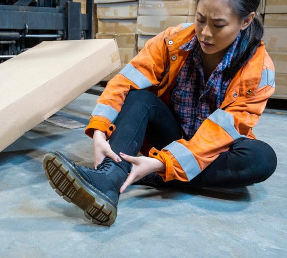 Female-worker-touching-her-ankle-after-a-fall Female-worker-touching-her-ankle-after-a-fall