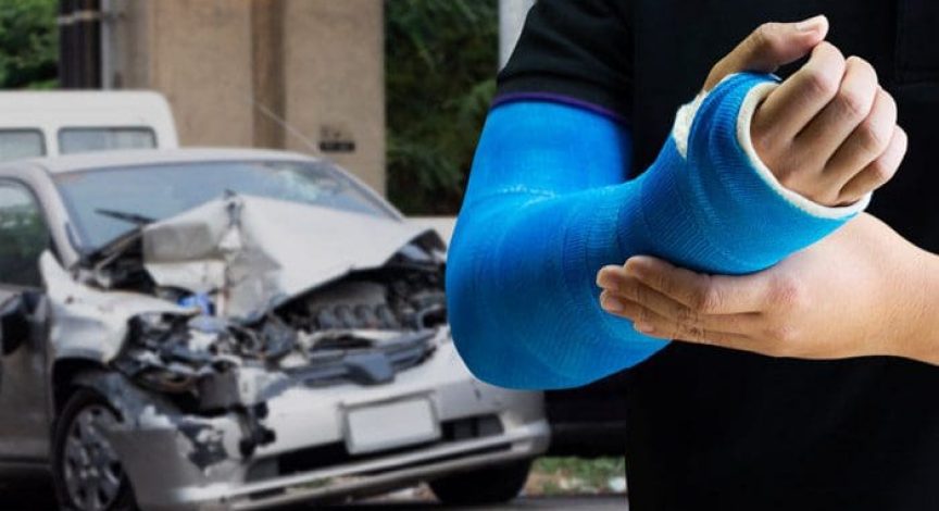 Close-up-of-man-with-a-blue-arm-cast-with-car-accident-in-the-background