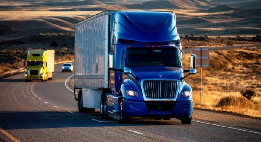 Two-semi-trucks-and-a-passenger-vehicle-on-a-highway