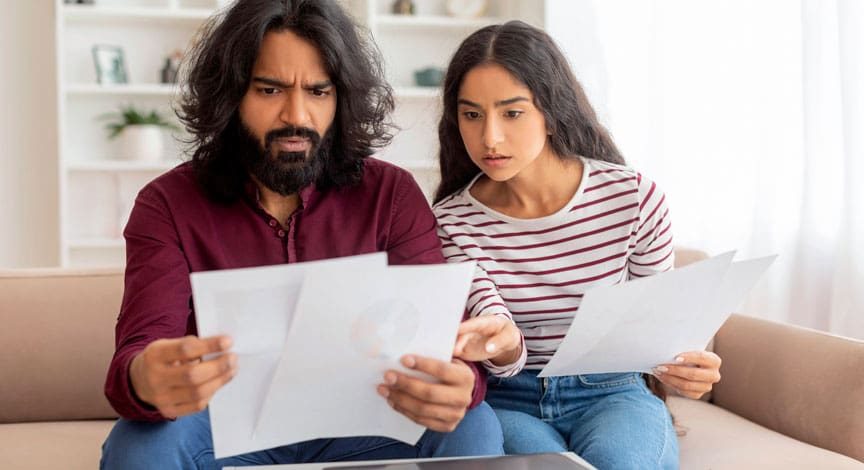 man-and-teenage-girl-reviewing-paperwork-together-on-a-couch