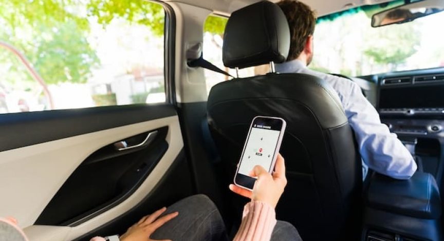 passenger using rideshare app in car