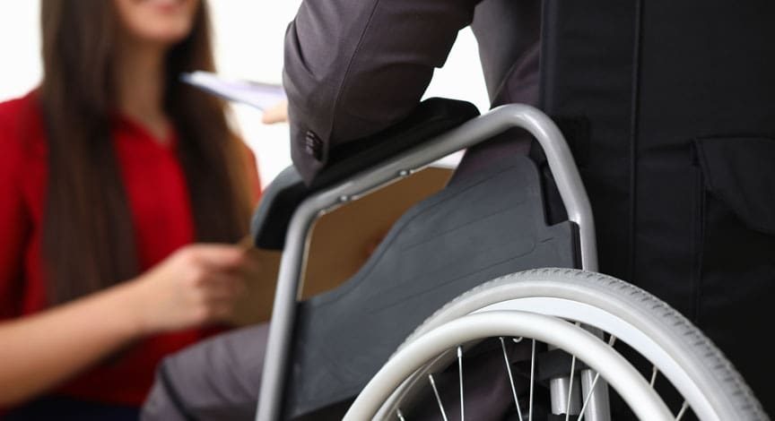 woman-in-a-wheelchair-talking-with-someone-in-an-office